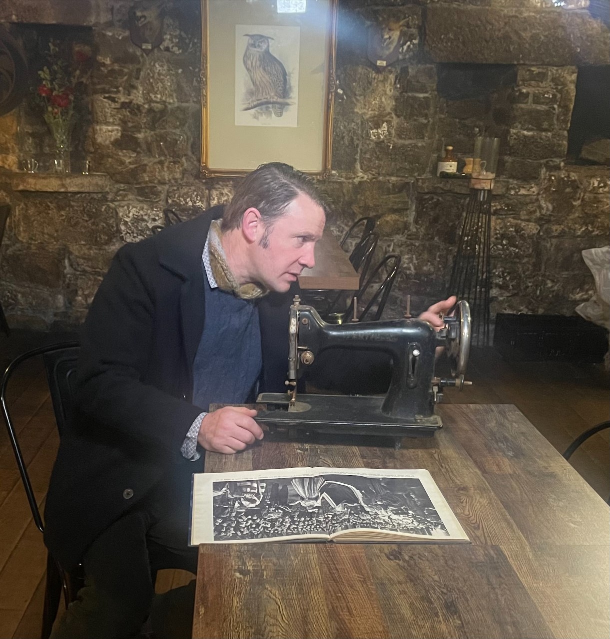 Curator of Public History Jon Addison looking at an old sewing machine