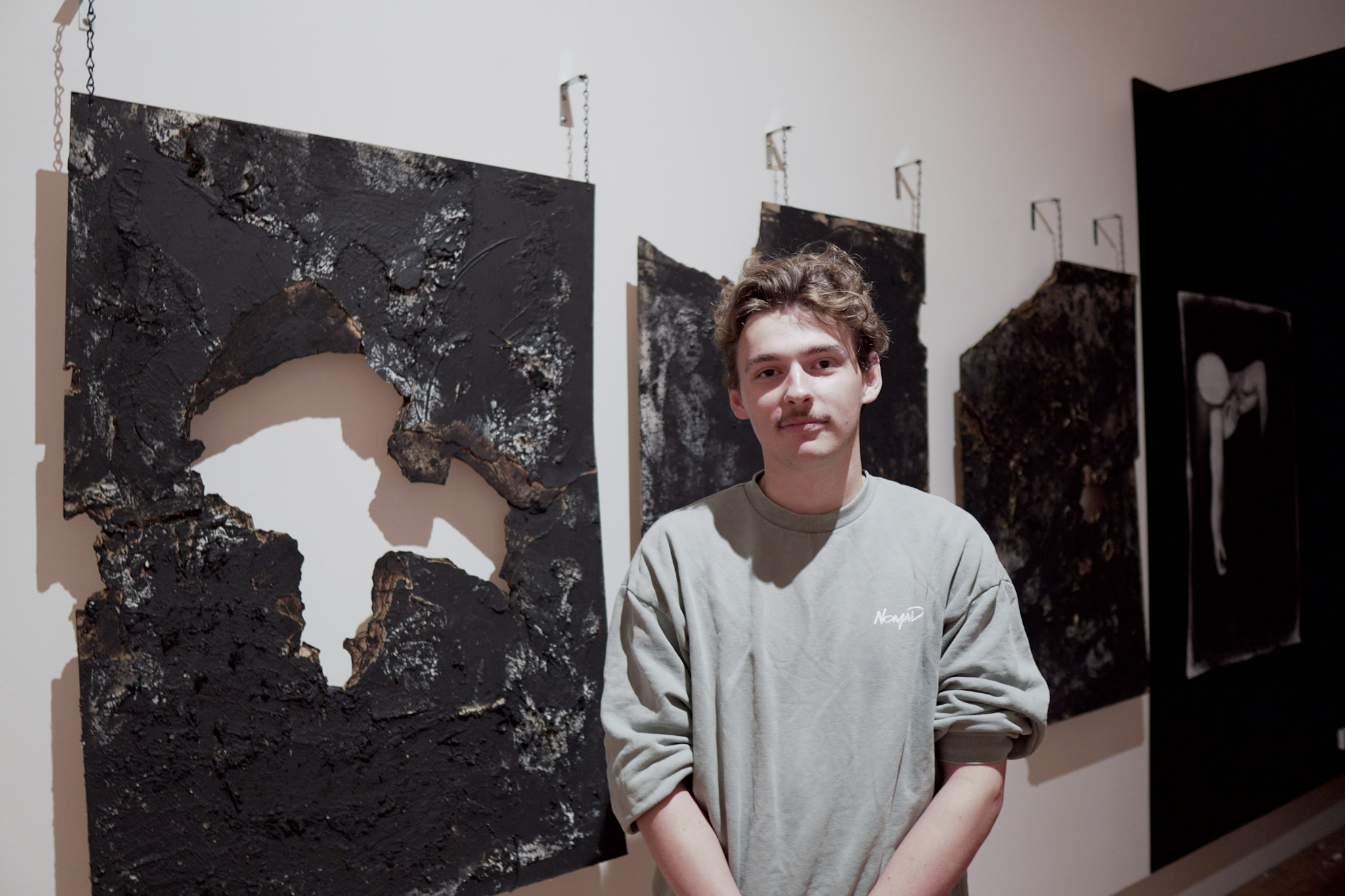 ArtRage 2023 artist Thomas stands next to his work, entitled Self Discovery