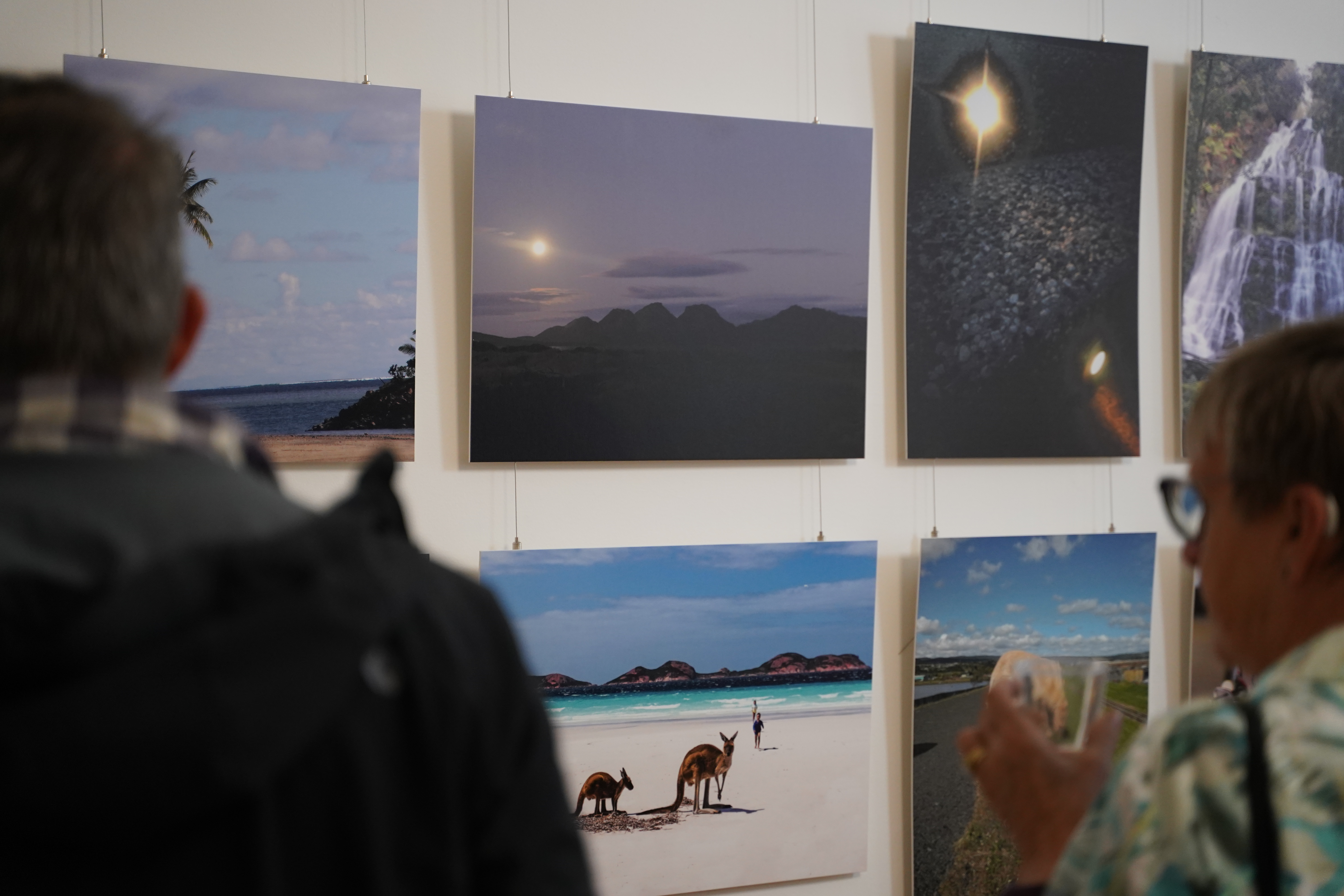 Gallery exhibition wall with two people viewing the artworks as part of The Big Picture exhibition