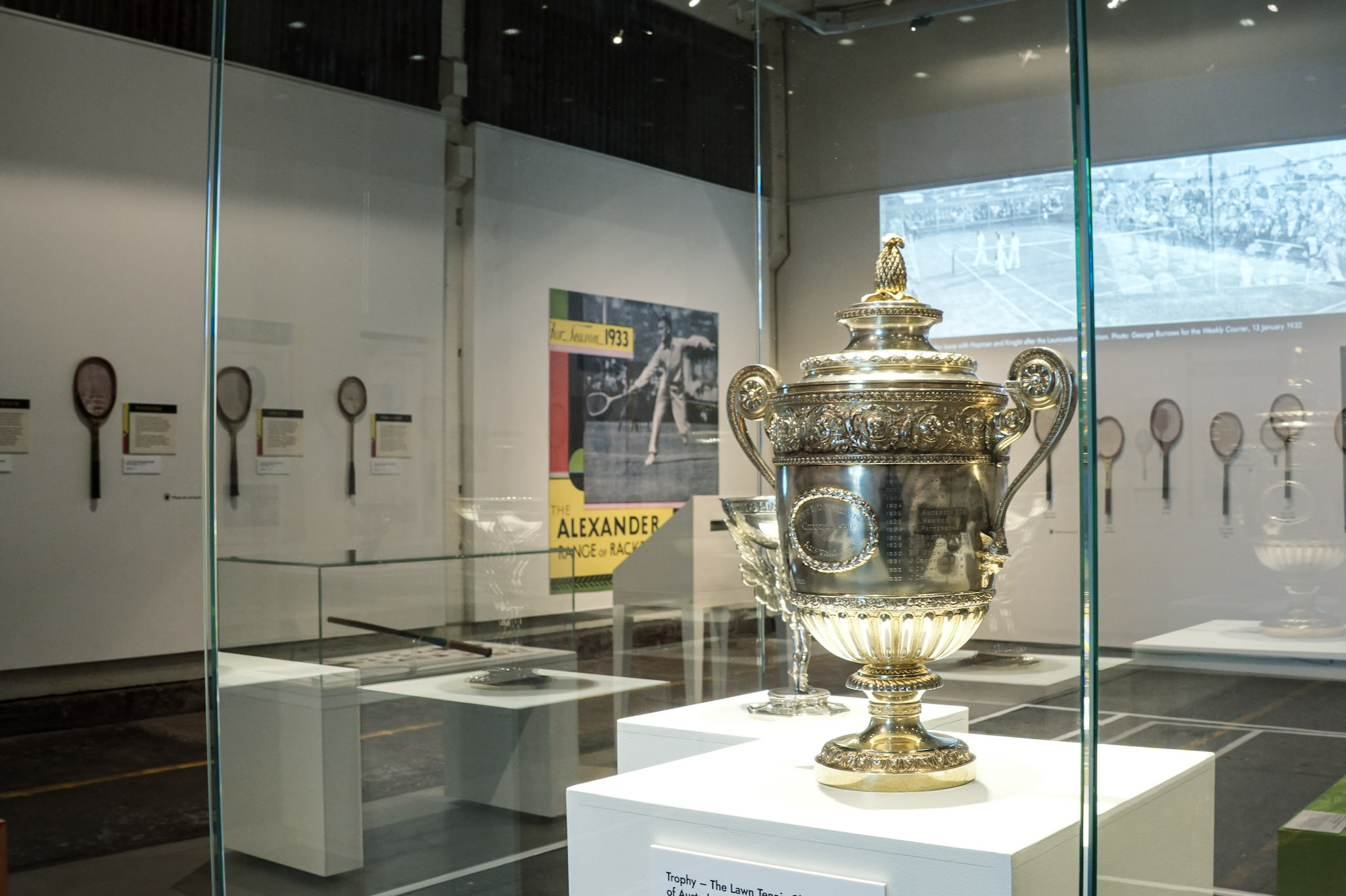 A large sterling silver trophy cup, featuring a pineapple decoration on the top.