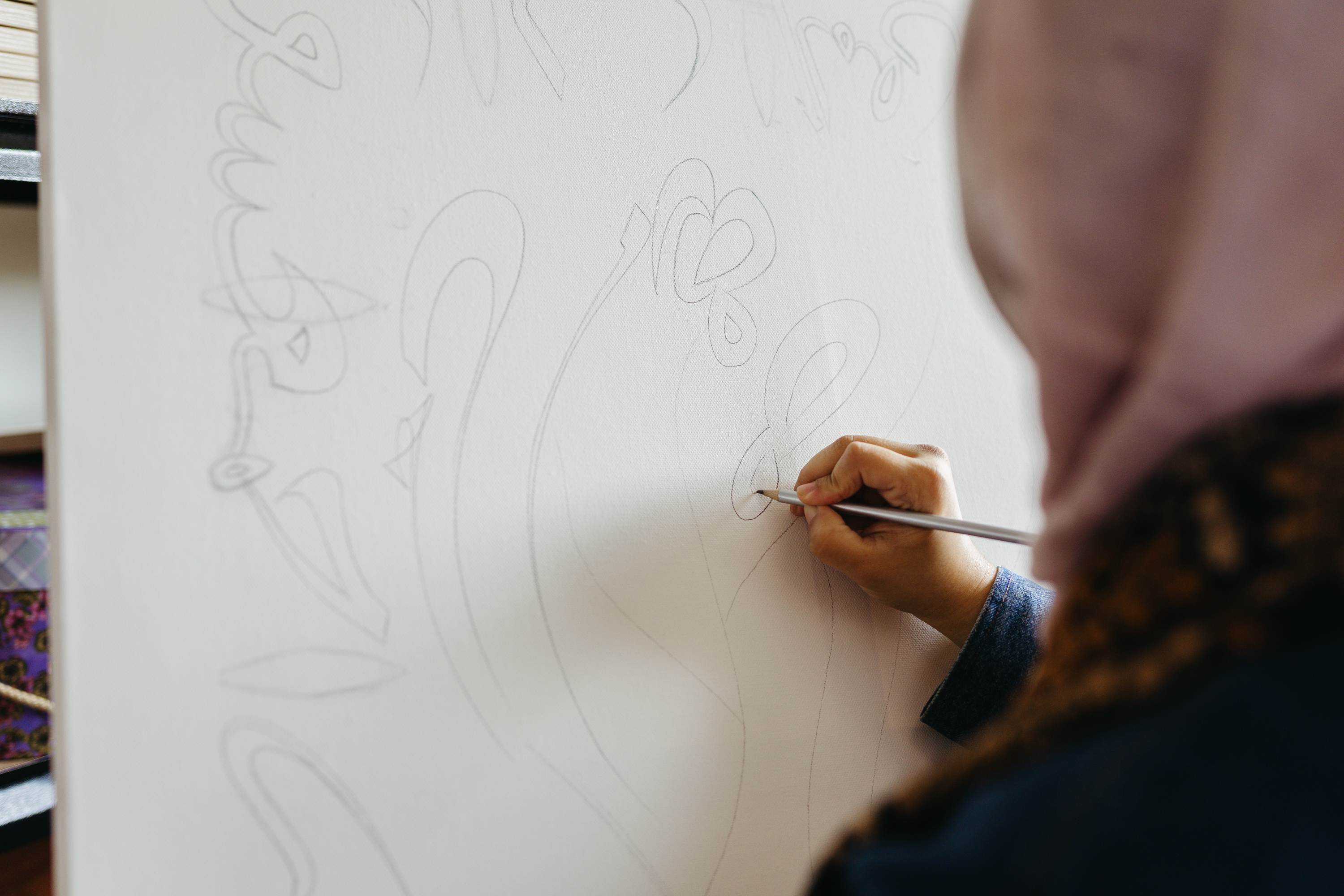 Close up of RISE artist Halima Bhatti sketching