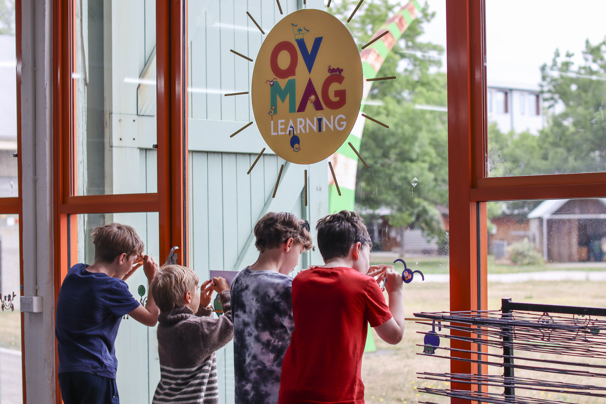 Children drawing up against the glass windows of the Learning Centre