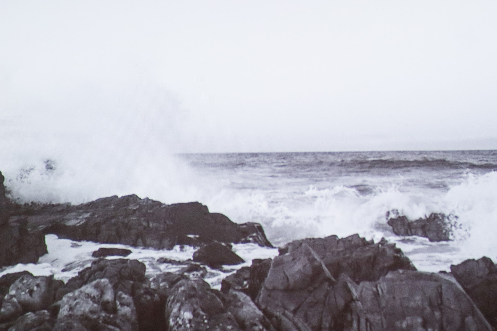 Still of waves splashing against rocks in Mali Davis' video 'the quieter you are, the more you can hear'.